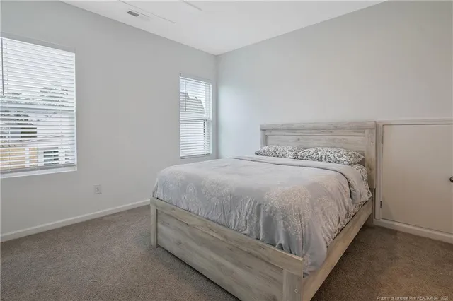 a spacious bedroom with a bed and a window