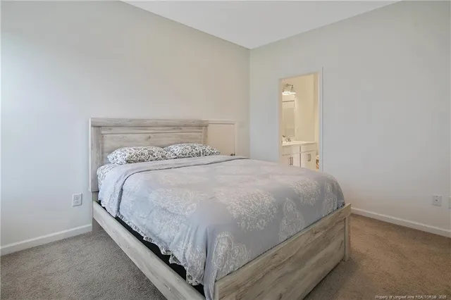 a bed sitting in a bedroom next to a window and a wooden floor