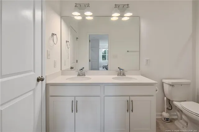 a bathroom with a sink a toilet and a mirror
