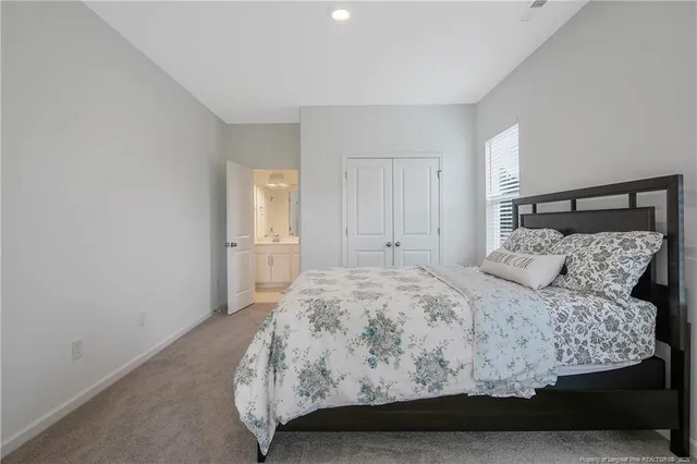 a bedroom with a large bed and wooden floor