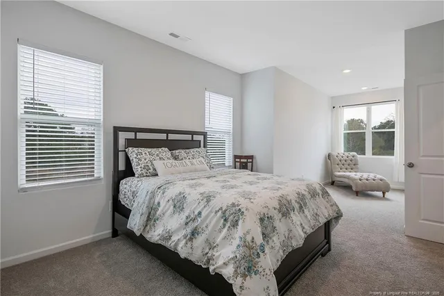 a bed sitting in a bedroom next to a window