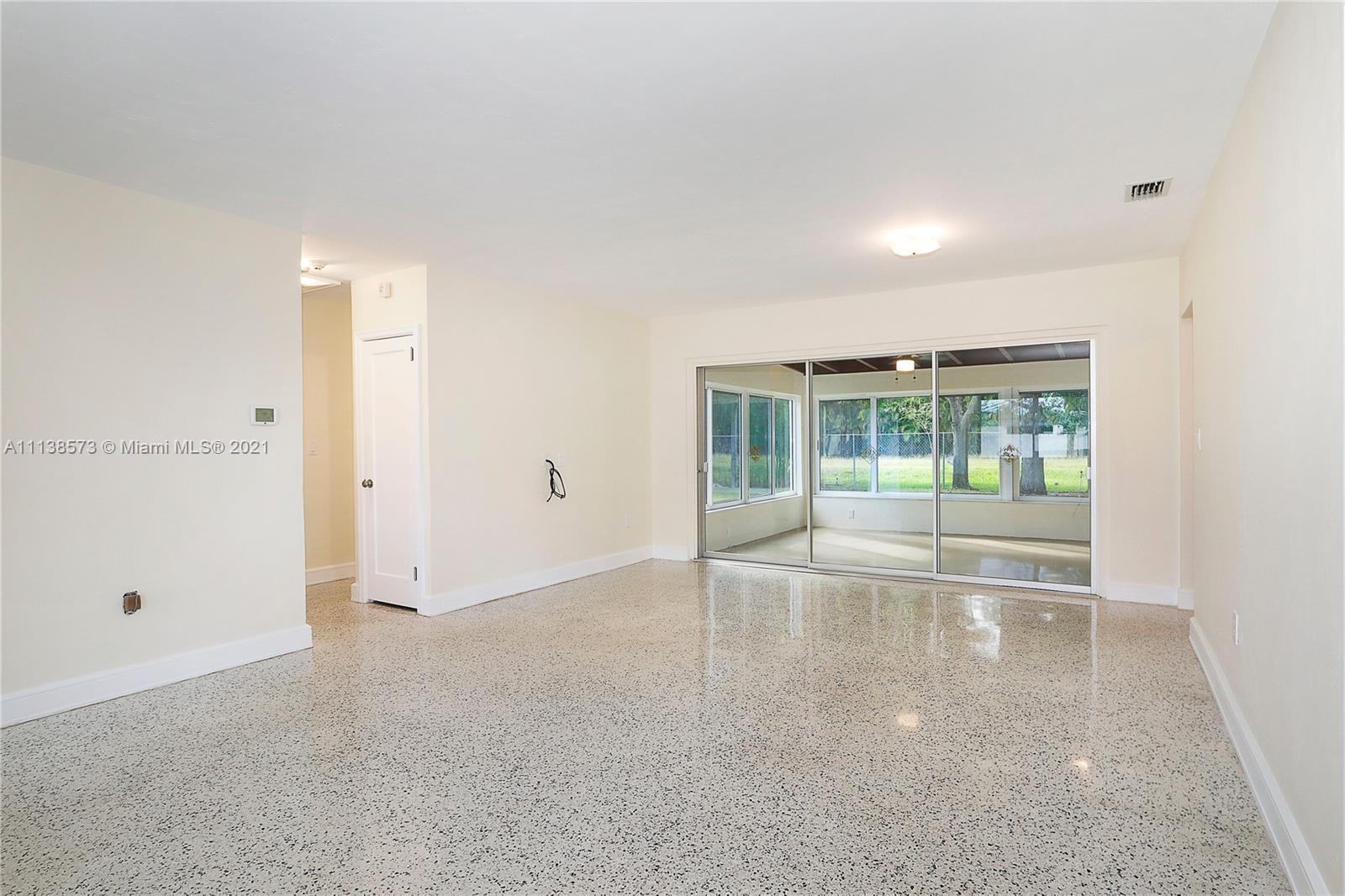 Glenvar Heights Miami, FL 33155 - Photo 8 of 22 an empty room with wooden floor and windows
