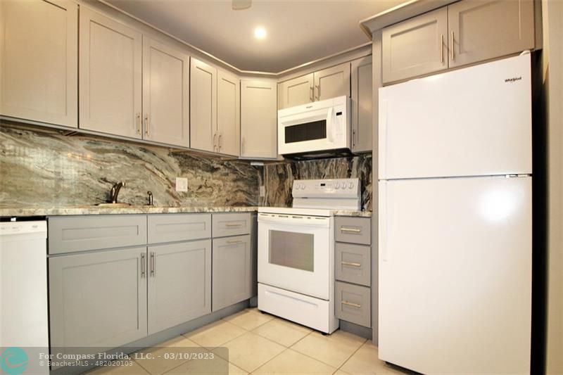 a kitchen with appliances a sink and cabinets