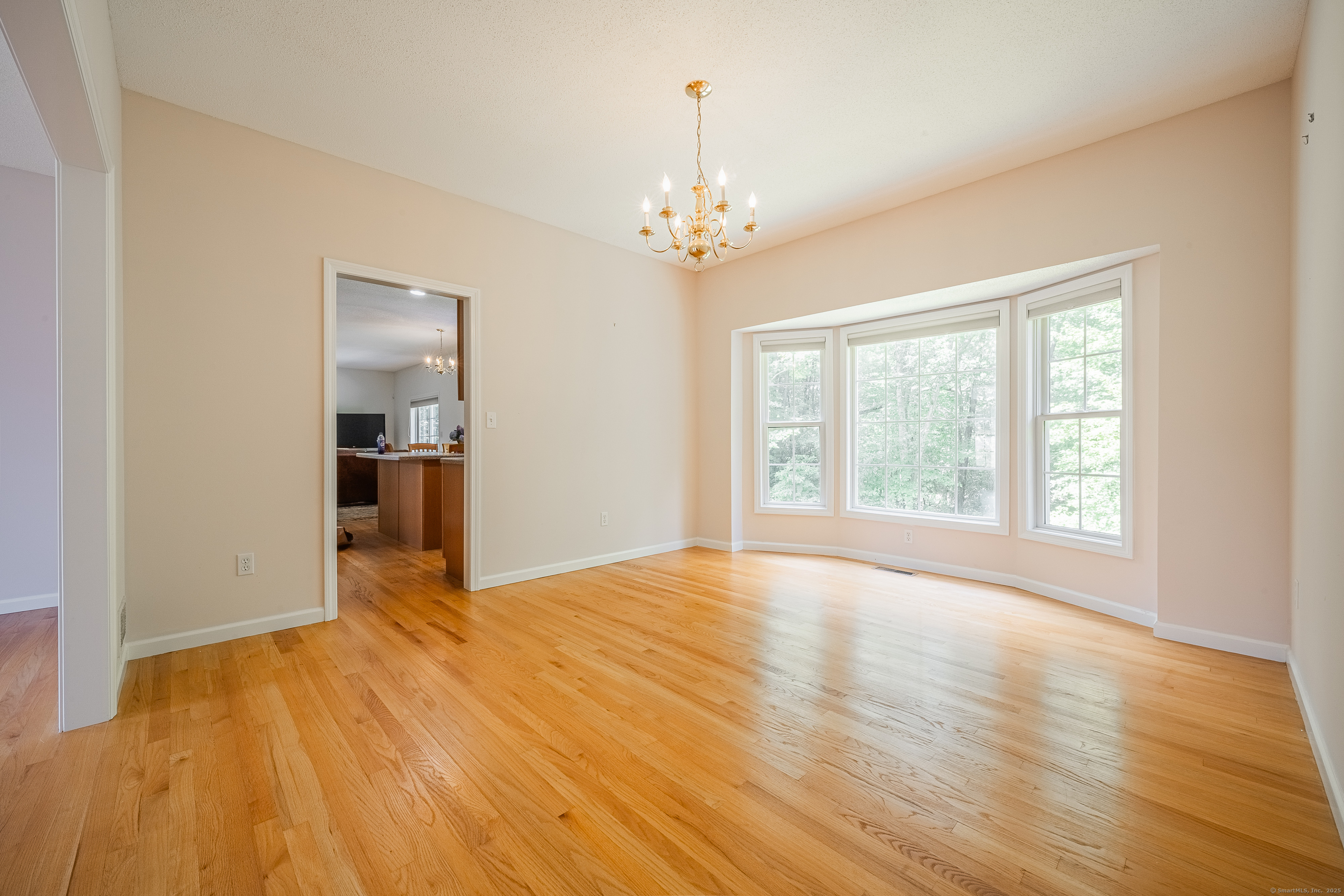 52 Quarry Lane Hamden, CT 06518 - Photo 13 of 29 a view of an empty room with window and wooden floor