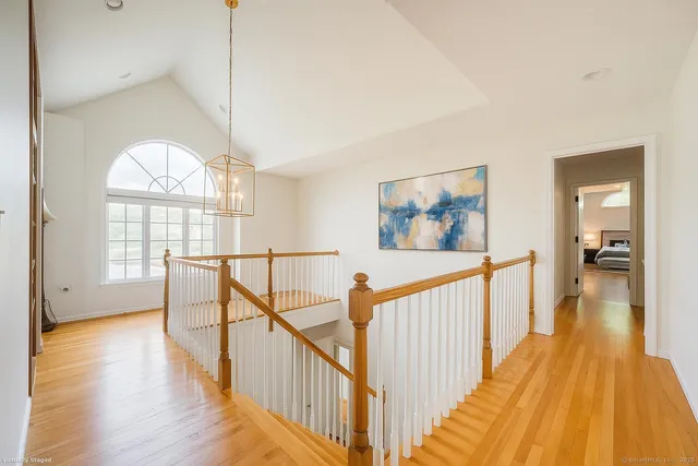 a view of a hallway with wooden floor and stairs