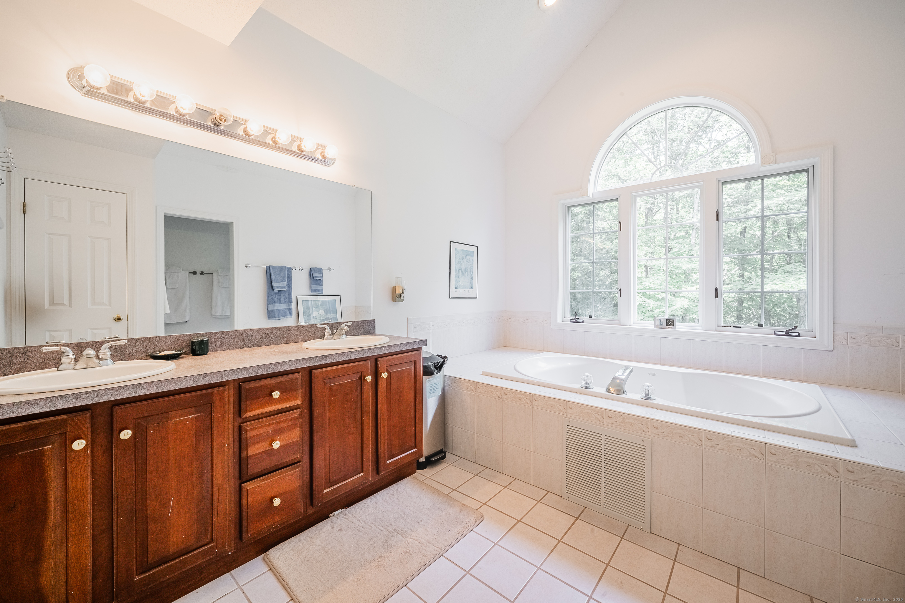 52 Quarry Lane Hamden, CT 06518 - Photo 17 of 29 a spacious bathroom with a double vanity sink a large mirror and a bathtub