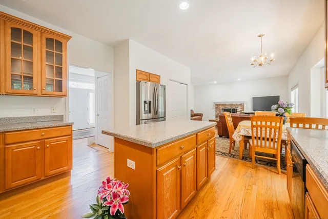 a kitchen with stainless steel appliances granite countertop a sink a stove and a wooden floors