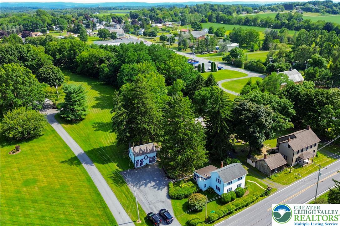 666 Point Phillips Road Bath, PA 18014 - Photo 13 of 68 An aerial perspective reveals a charming residential property nestled amidst verdant fields and a tree-lined landscape.