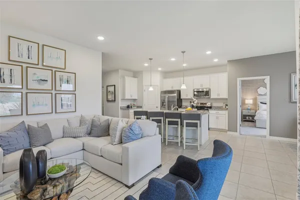 a living room with furniture kitchen and a table