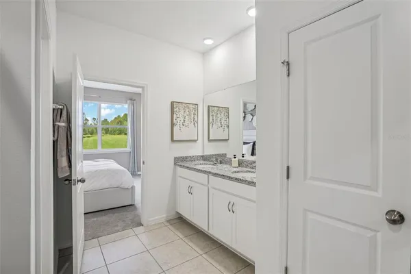 a en suite bathroom with a granite countertop sink and a mirror