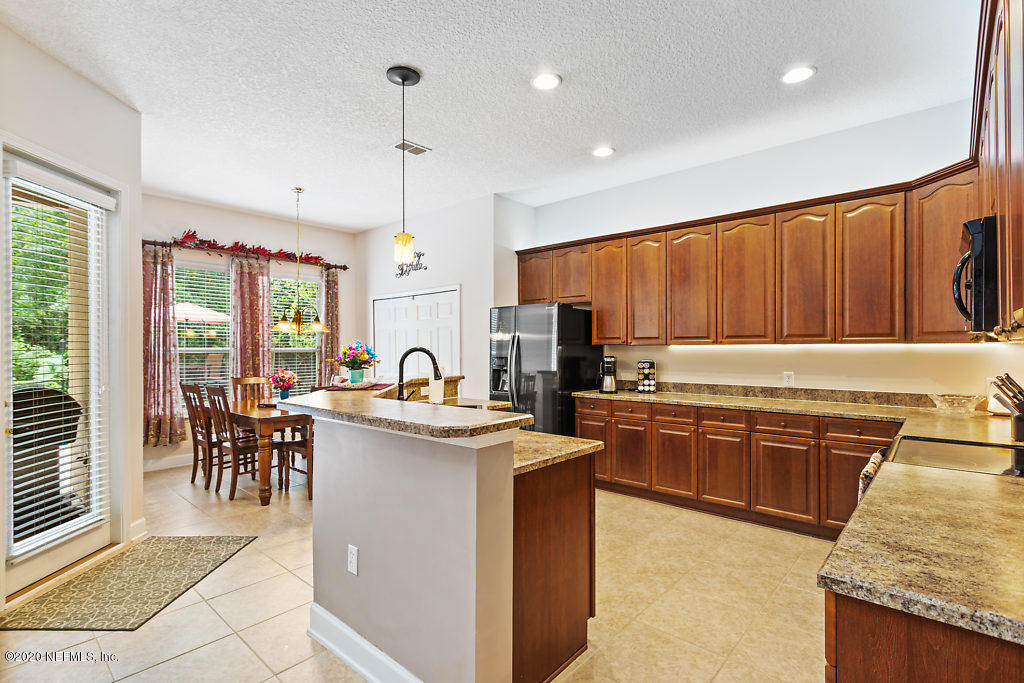 3824 Reds Gait Lane Jacksonville, FL 32223 - Photo 15 of 68 a kitchen with kitchen island granite countertop a sink stove and cabinets
