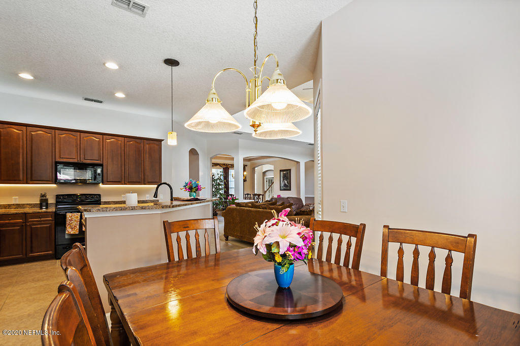 3824 Reds Gait Lane Jacksonville, FL 32223 - Photo 18 of 68 a kitchen with stainless steel appliances wooden floor dining table and chairs