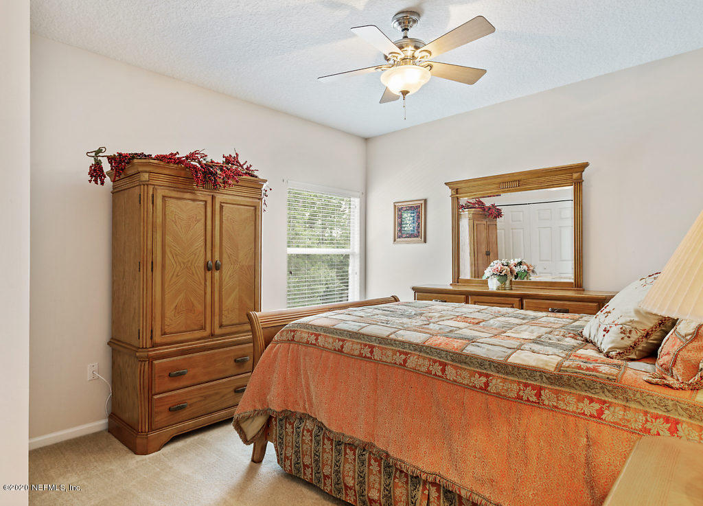 3824 Reds Gait Lane Jacksonville, FL 32223 - Photo 43 of 68 a bedroom with a bed and a chandelier