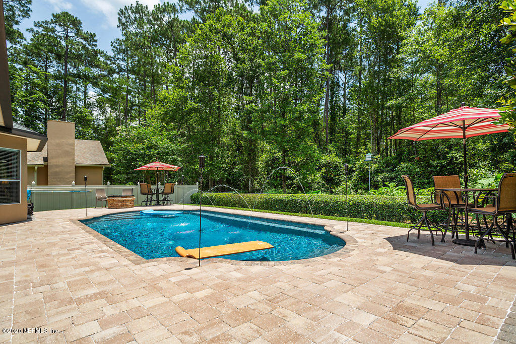 3824 Reds Gait Lane Jacksonville, FL 32223 - Photo 67 of 68 a view of a swimming pool with chair and table under an umbrella