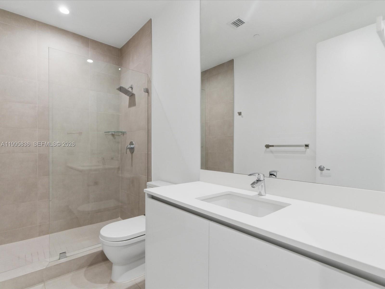 529 Southwest 11th Street, Unit 303 Miami, FL 33129 - Photo 22 of 35 a bathroom with a sink a toilet and shower