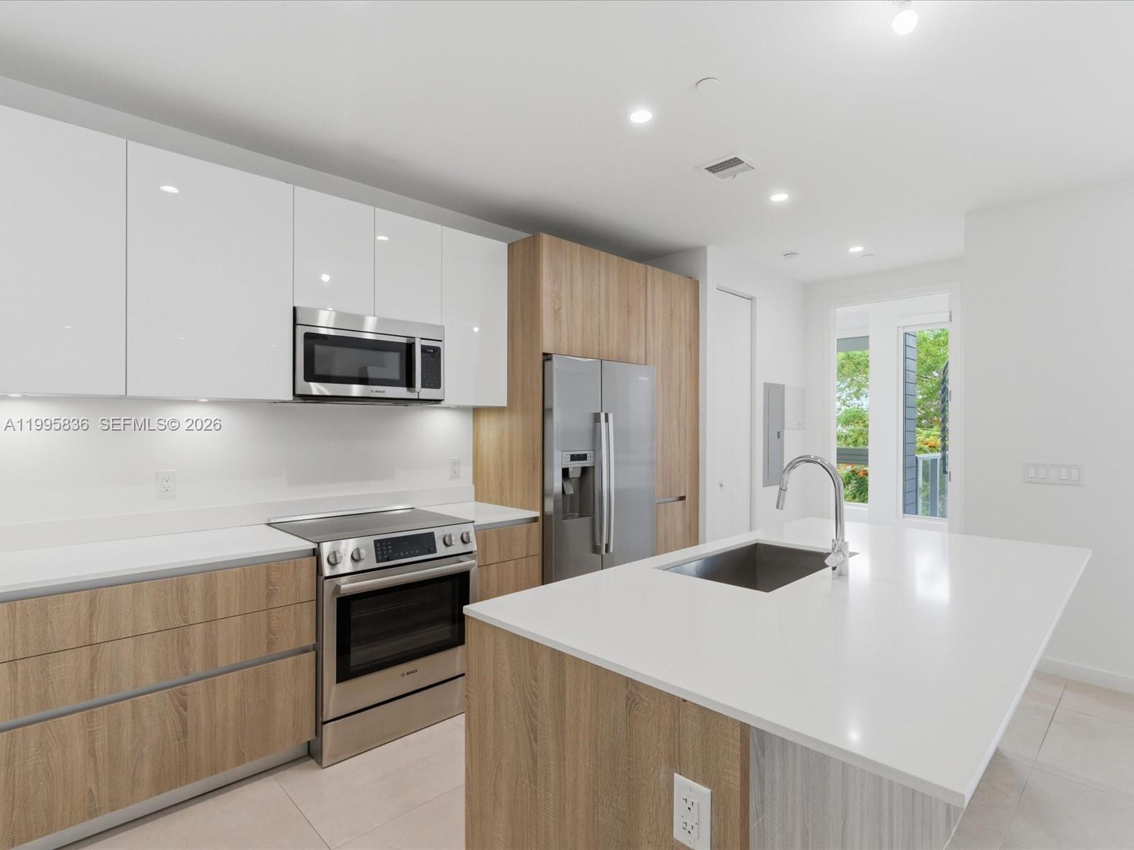 529 Southwest 11th Street, Unit 303 Miami, FL 33129 - Photo 6 of 35 a kitchen with stainless steel appliances a sink stove and refrigerator