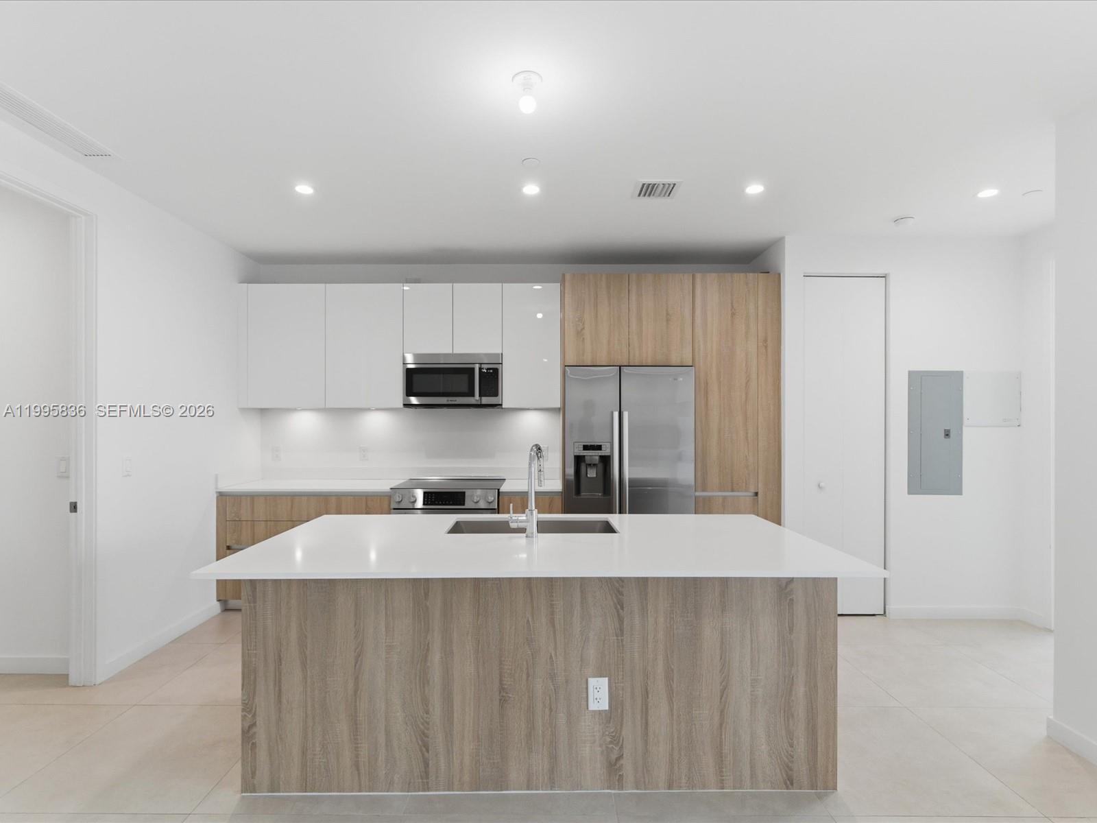 529 Southwest 11th Street, Unit 303 Miami, FL 33129 - Photo 7 of 35 a kitchen with stainless steel appliances a sink a stove a refrigerator and cabinets