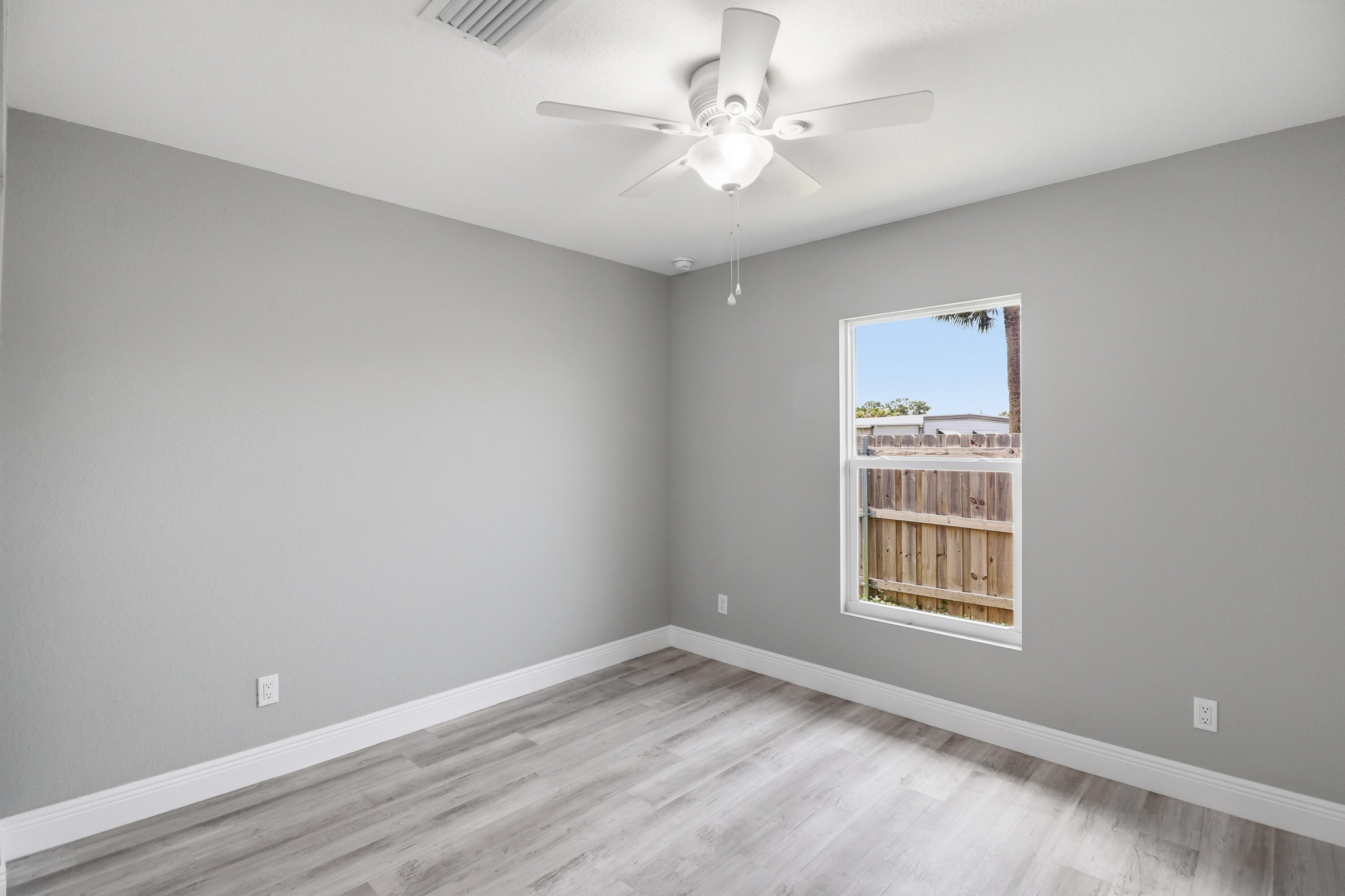 2805 Southeast Carroll Street Stuart, FL 34997 - Photo 16 of 21 an empty room with windows and ceiling fan
