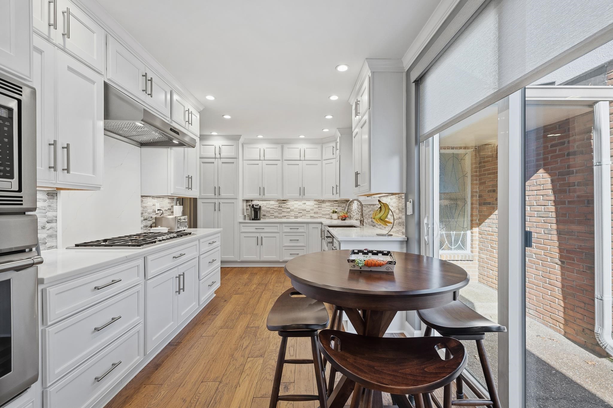 4050 Baronne Way, Unit 34 Memphis, TN 38117 - Photo 16 of 32 a kitchen with a dining table chairs and white cabinets