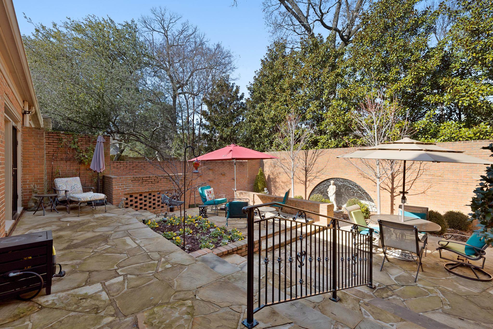 4050 Baronne Way, Unit 34 Memphis, TN 38117 - Photo 29 of 32 a view of a patio with table and chairs under an umbrella with large trees