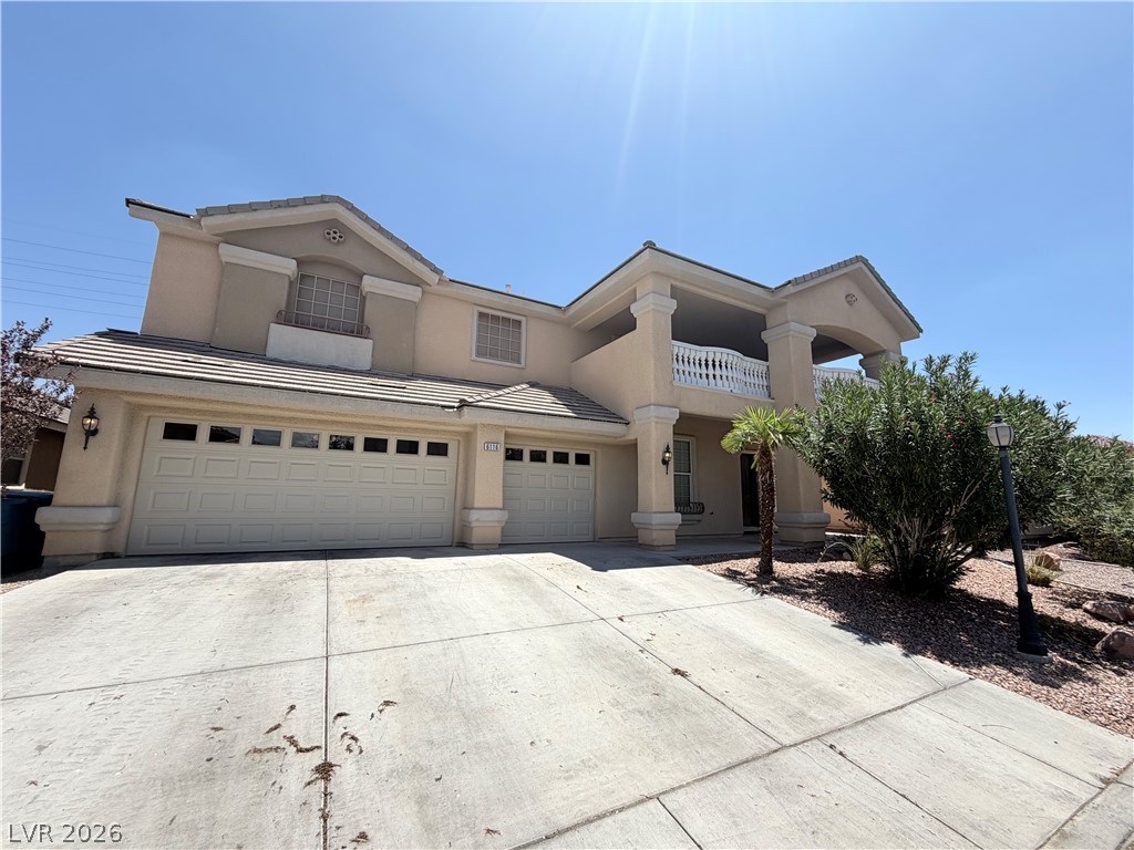 6116 Rabbit Track Street Las Vegas, NV 89130 - Photo 1 of 28 A grand entrance with a spacious balcony and inviting two-car garage awaits.