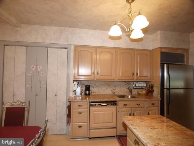 1001 Loxford Terrace Silver Spring, MD 20901 - Photo 8 of 25 a kitchen with stainless steel appliances granite countertop a refrigerator a stove a sink and white cabinets