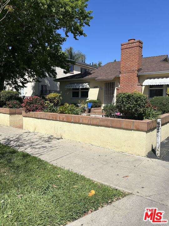 14757 Sylvan Street Van Nuys, CA 91411 - Photo 1 of 6 a front view of a house with yard and lake view