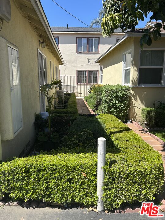 14757 Sylvan Street Van Nuys, CA 91411 - Photo 2 of 6 a front view of a house with garden