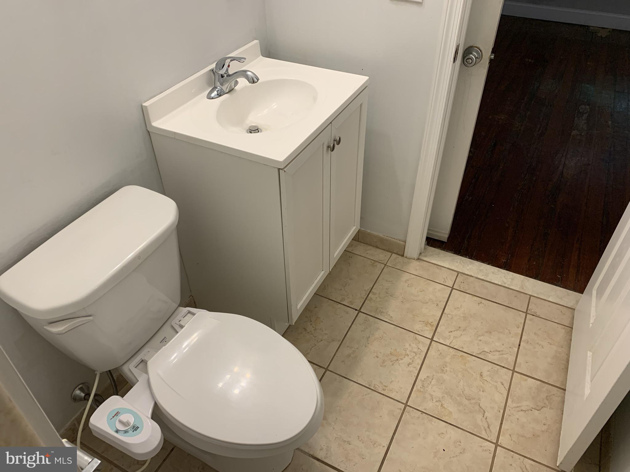 4437 Chestnut Street, Unit 1F Philadelphia, PA 19104 - Photo 14 of 15 a bathroom with a toilet a sink and mirror