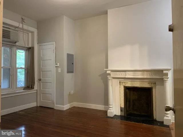 a view of a livingroom with wooden floor and a fireplace
