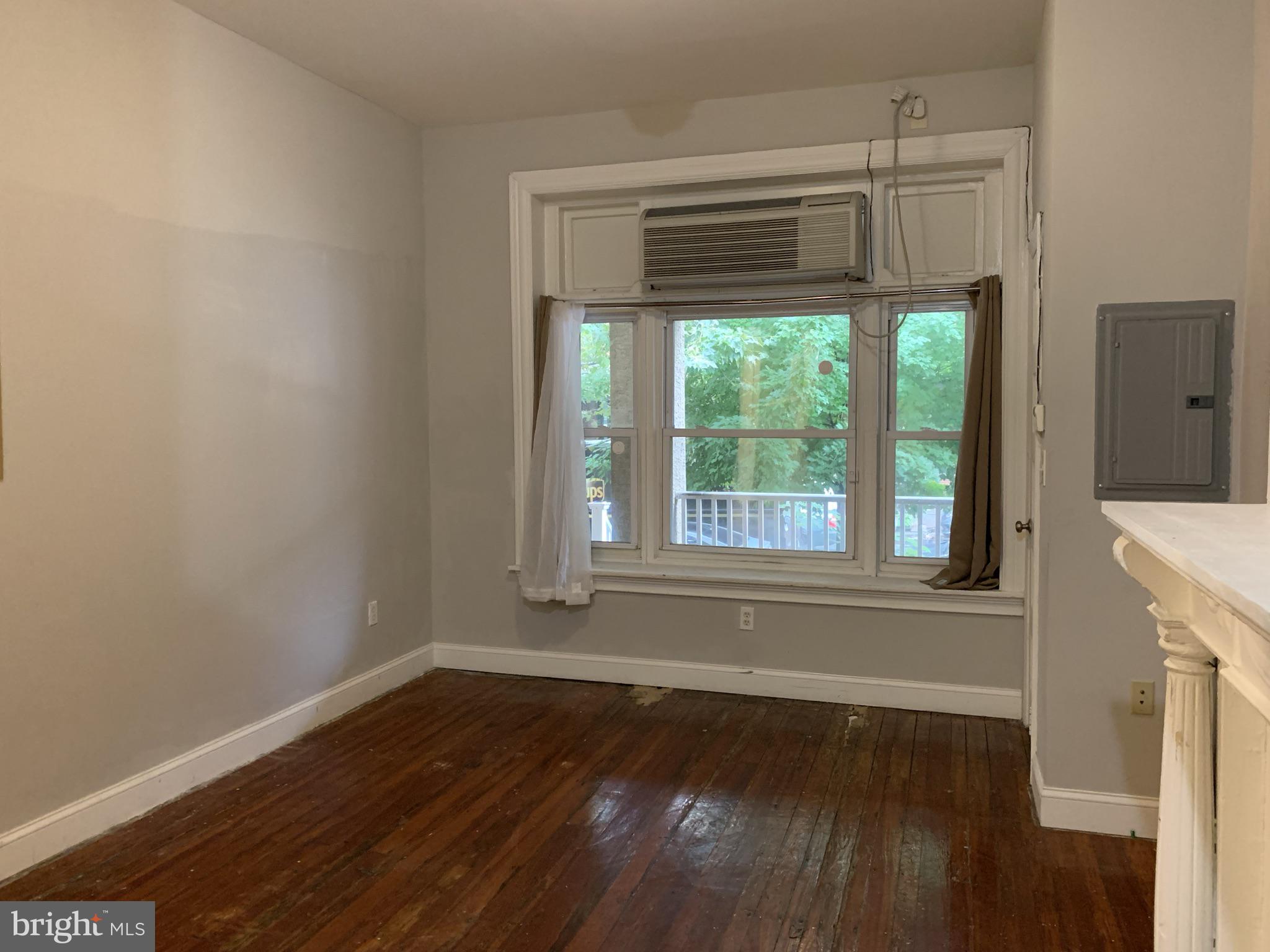 4437 Chestnut Street, Unit 1F Philadelphia, PA 19104 - Photo 5 of 15 a view of empty room with wooden floor and fan