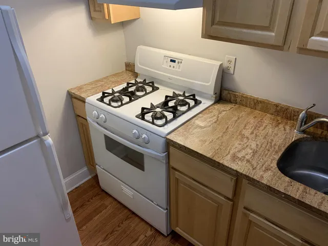 a white stove top oven sitting inside of a kitchen