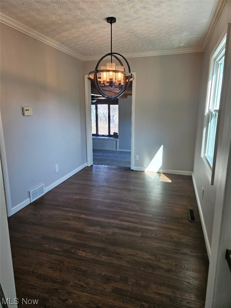 3439 Surrey Road Southeast Warren, OH 44484 - Photo 19 of 32 Dining room with a chandelier, crown molding, a textured ceiling, and refinished hardwood flooring