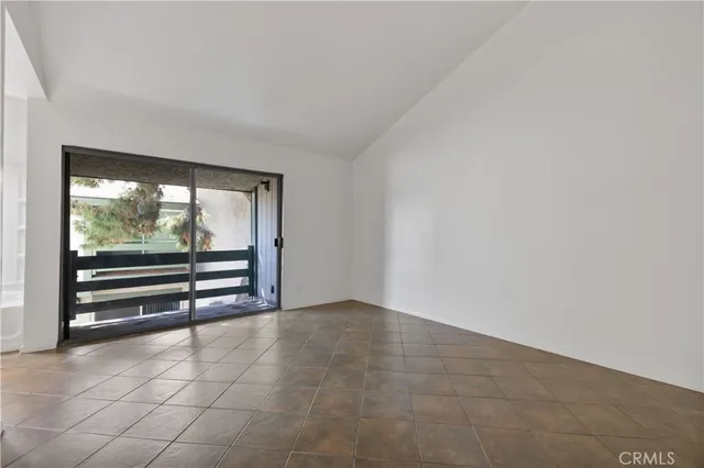 a view of an empty room with window and cabinet