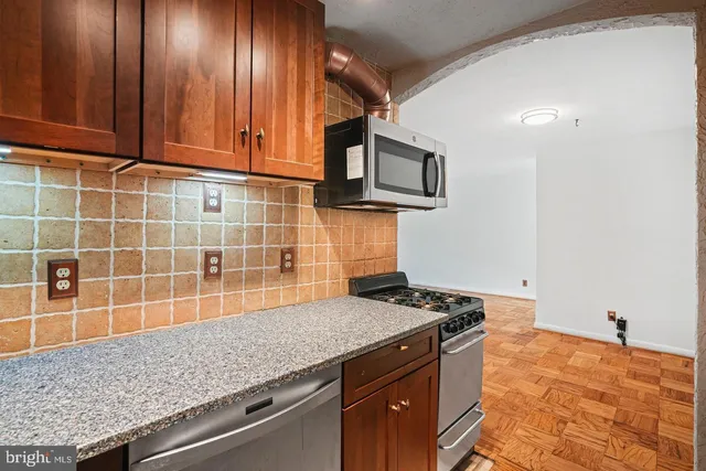 a kitchen with granite countertop stainless steel appliances a sink and cabinets