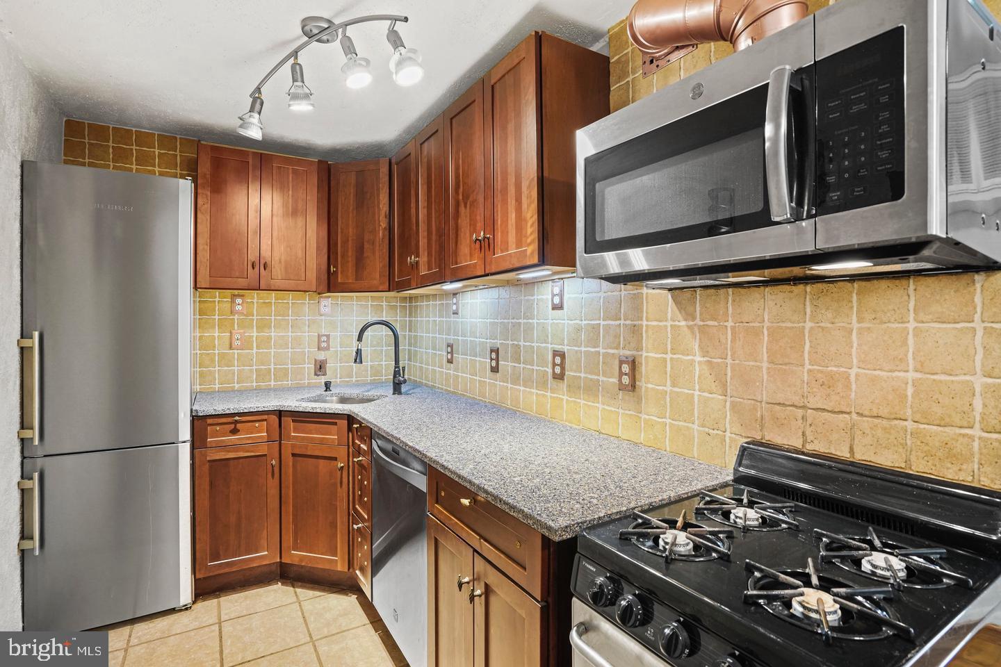 575 Thayer Avenue, Unit 404 Silver Spring, MD 20910 - Photo 10 of 26 a kitchen with a stove and a microwave