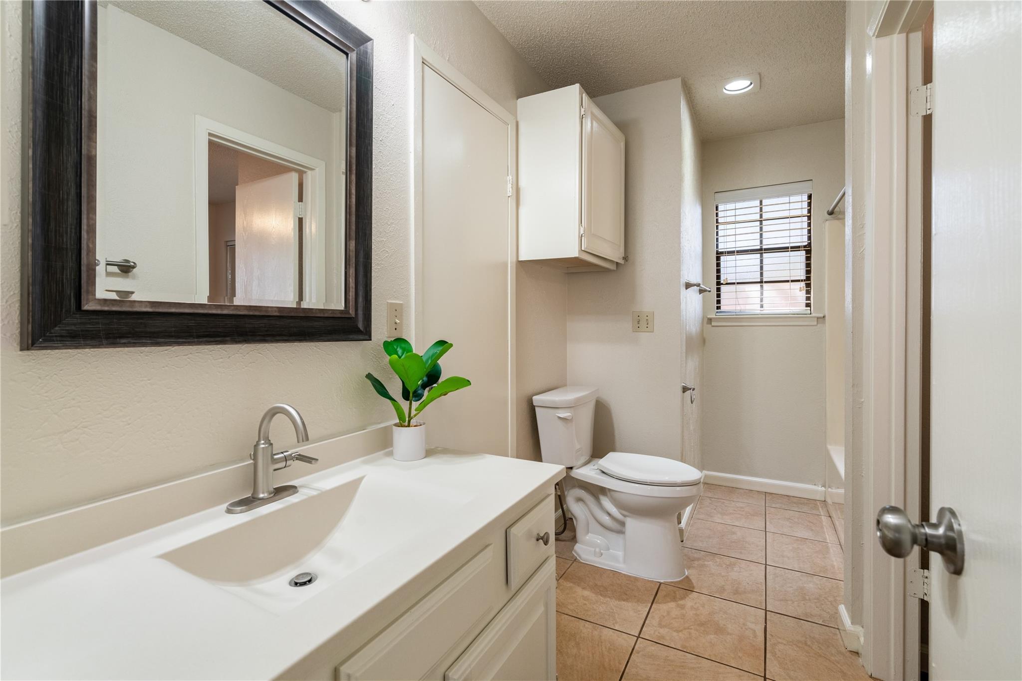 3800 Foust Trail, Unit B Georgetown, TX 78628 - Photo 9 of 16 A compact bathroom offers functionality with a vanity, mirror, and tiled flooring.