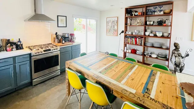 a kitchen that has a stove and a table in it