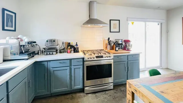 a kitchen with stainless steel appliances granite countertop a sink stove and cabinets