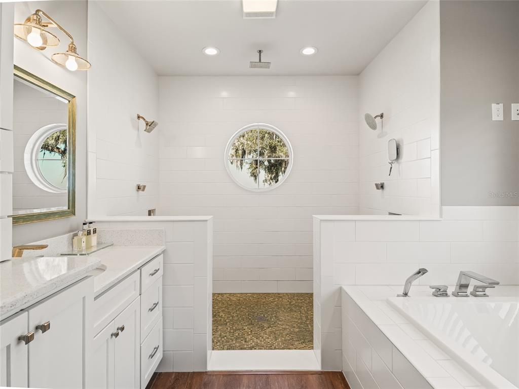 12943 Southeast Sunset Harbor Road Weirsdale, FL 32195 - Photo 35 of 87 a bathroom with a sink a mirror a vanity and a bathtub