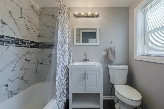 a white toilet sitting next to a bath tub