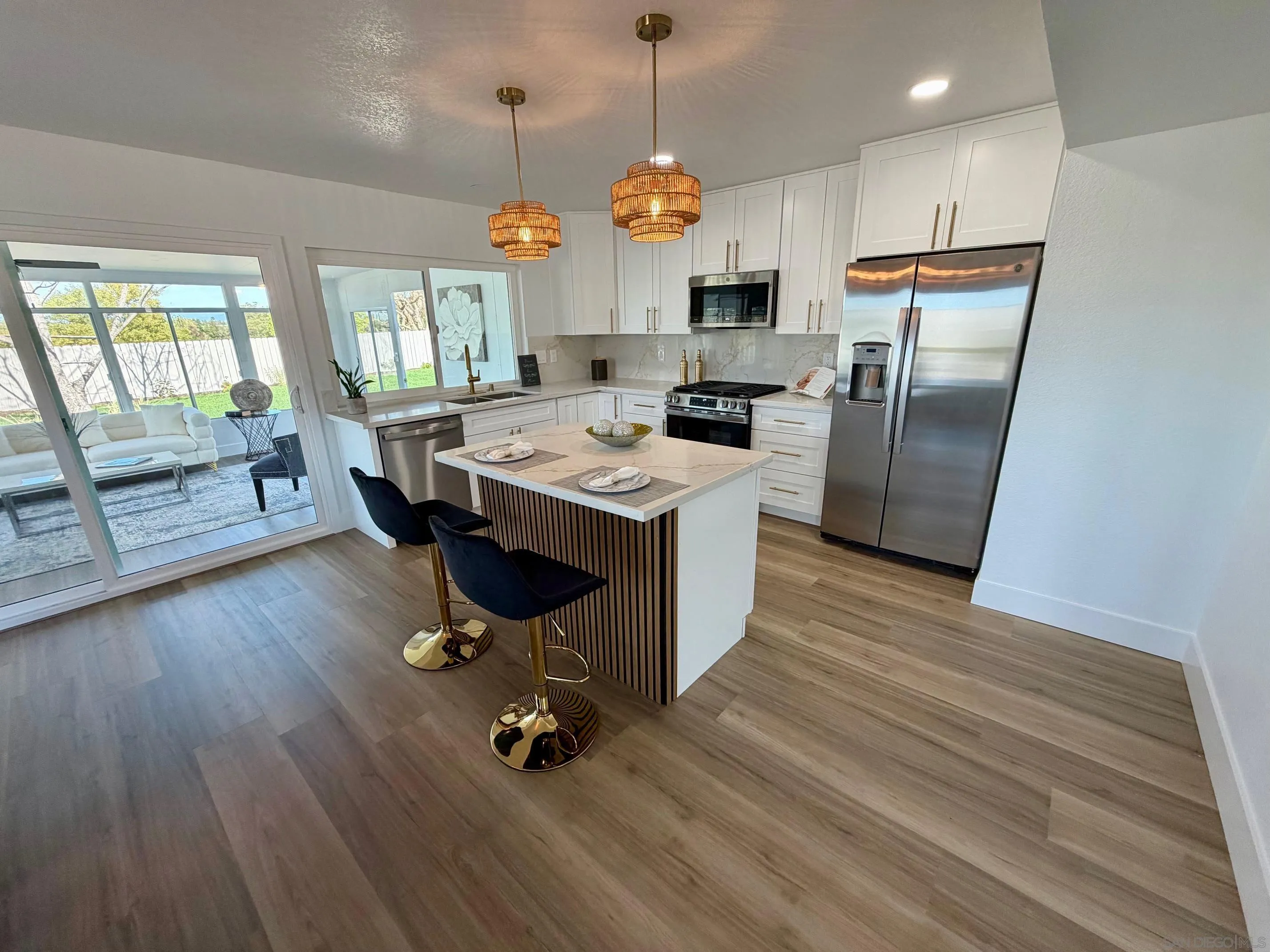 4128 Terry Street Oceanside, CA 92056 - Photo 5 of 21 a kitchen with granite countertop a stove a refrigerator a oven a sink with island and wooden floor