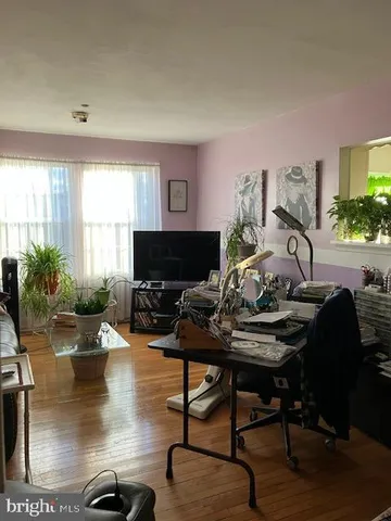 a living room with furniture a flat screen tv and a large window