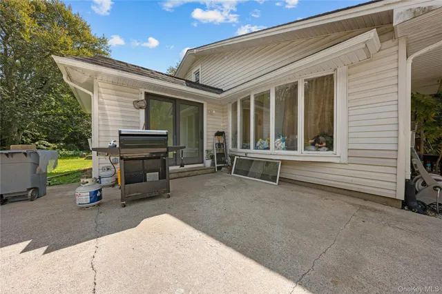 a backyard of a house with barbeque oven table and chairs