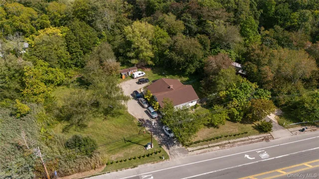 an aerial view of residential house with outdoor space and trees all around