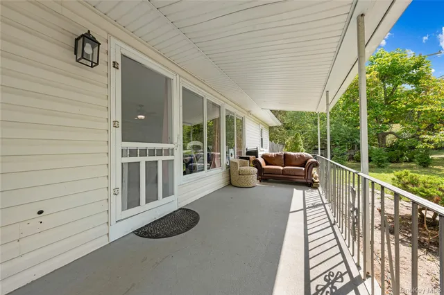 a view of a patio with couches and table and chairs with wooden floor and fence