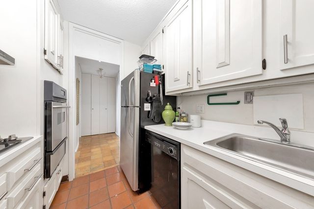 a kitchen with stainless steel appliances granite countertop a refrigerator and a stove