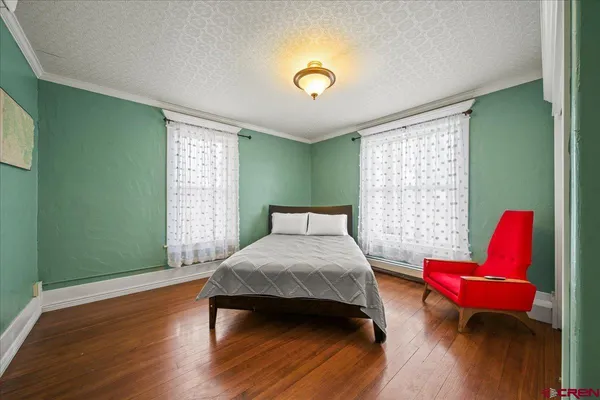 a bedroom with a bed and a wooden floor