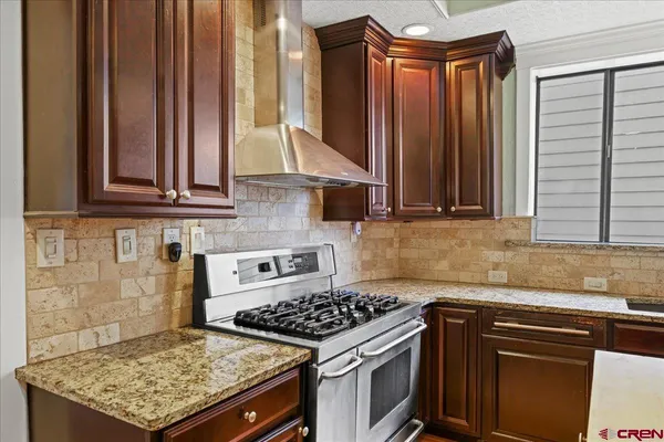a kitchen with stainless steel appliances granite countertop a stove a sink and a microwave
