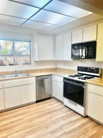 a kitchen with stainless steel appliances white cabinets and a sink